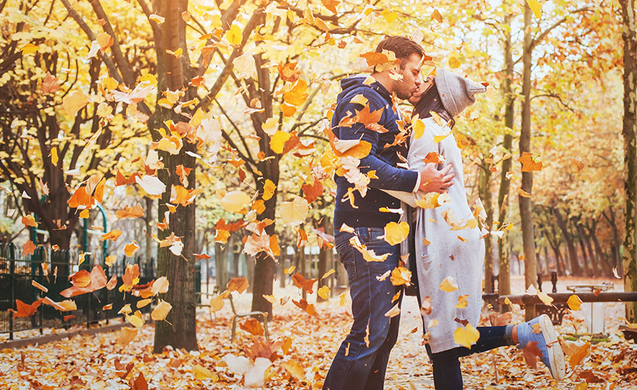 couple hugging autumn leaves