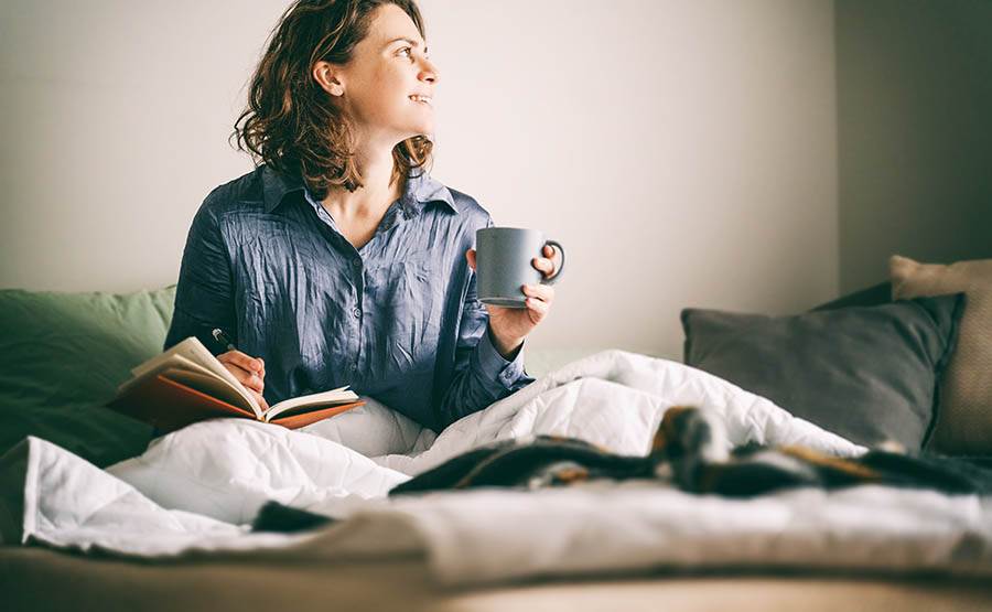 A woman journaling with a cup of coffee